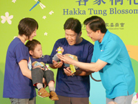 客委會主委黃玉振（右一）贈送桐花公仔給桐花寶寶（左二）