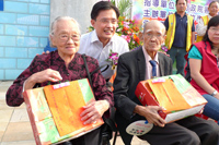 行政院客委會主委黃玉致贈紀念品給高齡95歲的張盧月妹與91歲的徐阿灶