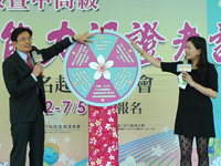 行政院客委會主委黃玉振於記者會上轉動客語認證好康輪盤。