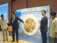 行政院客委會主委黃玉振拼出客家經典菜餚「客家小炒」，並解說其由來。