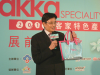 行政院客委會主委黃玉振手持「2010客家特色產業展」開幕當天發送的限量「繽客好禮」，邀請大家一同共襄盛舉